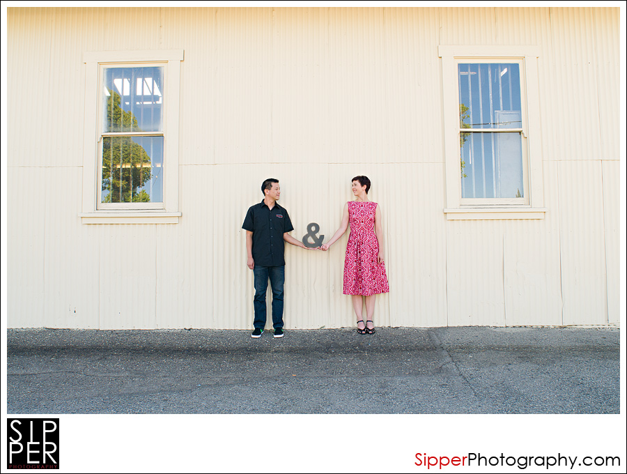Engagement portrait with couple and ampersand sign